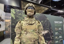 Balancing Protection and Performance: The Evolution of Military Textiles and Personal Protective Equipment (PPE) at Sioen Industries A modern military protective system displayed at a defense exhibition, featuring advanced camouflage textiles, modular body armor, and integrated soldier protection technologies developed for contemporary operational environments.