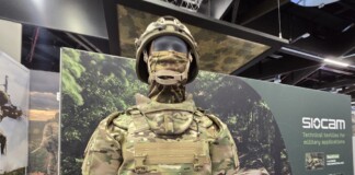 Balancing Protection and Performance: The Evolution of Military Textiles and Personal Protective Equipment (PPE) at Sioen Industries A modern military protective system displayed at a defense exhibition, featuring advanced camouflage textiles, modular body armor, and integrated soldier protection technologies developed for contemporary operational environments.
