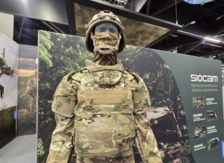 Balancing Protection and Performance: The Evolution of Military Textiles and Personal Protective Equipment (PPE) at Sioen Industries A modern military protective system displayed at a defense exhibition, featuring advanced camouflage textiles, modular body armor, and integrated soldier protection technologies developed for contemporary operational environments.