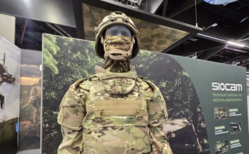 Balancing Protection and Performance: The Evolution of Military Textiles and Personal Protective Equipment (PPE) at Sioen Industries A modern military protective system displayed at a defense exhibition, featuring advanced camouflage textiles, modular body armor, and integrated soldier protection technologies developed for contemporary operational environments.