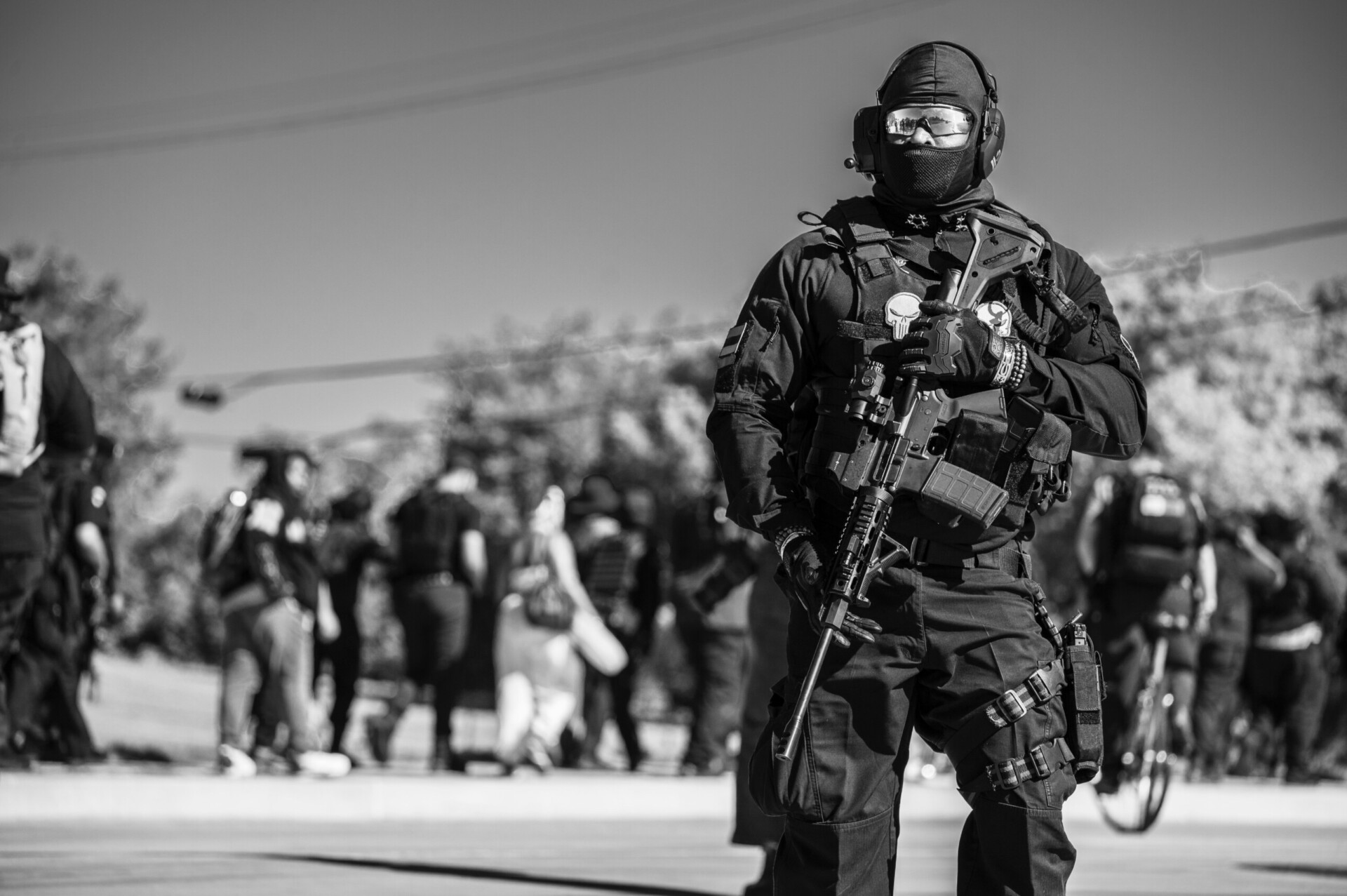 Security on the Front Line A heavily equipped tactical officer stands watch amid a public event, highlighting the importance of readiness and protective equipment in complex operational environments.