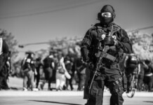 Where Protection Meets Performance: An Exclusive Interview with ANORAK CEO Dimitris Koskovos A heavily equipped tactical officer stands watch amid a public event, highlighting the importance of readiness and protective equipment in complex operational environments.