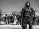 Where Protection Meets Performance: An Exclusive Interview with ANORAK CEO Dimitris Koskovos A heavily equipped tactical officer stands watch amid a public event, highlighting the importance of readiness and protective equipment in complex operational environments.